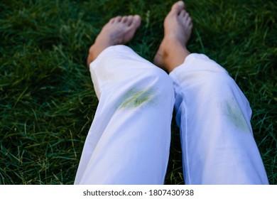 Girl's bare feet in the grass in the open.dirty grass stains on women's pants.daily life dirty stain for wash and clean concept