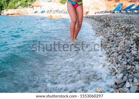 Girl's bare feet on a pebble beach