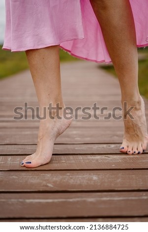 girl's barefoot on wooden path