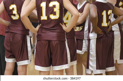 girls' basket ball team in a huddle