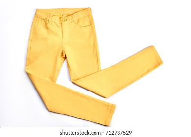 Girls beautiful yellow skinny trousers. Modern pockets yellow trousers for teenagers isolated on white background. Youth summer fashion apparel.