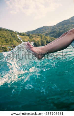 girl's beauty legs in the lake making splashes