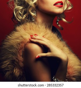 Girl's best friends and femme fatale concept. Marilyn Monroe style. Portrait of rich young woman wearing expensive luxurious diamond accessories, furs. Studio shot