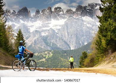 Girls with bikes are on the road in the woods and mountains of the Dolomites. Italy.