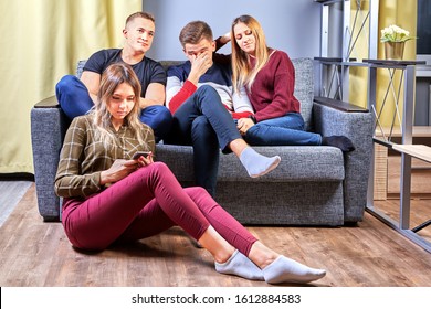 Girls With Boyfriends Watch A Boring Movie In A College Dorm. A Loving Couple Came To Visit Neighbors In A Student Dormitory. Young Men And Women Gathered In An Apartment In Front Of The TV.