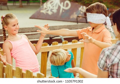 Girls and boys are playing in blindfolders on the playground.
