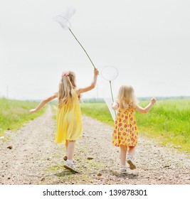 Girls with butterfly net having fun at field