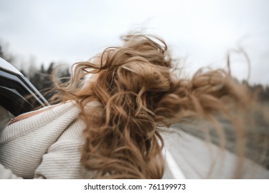 Girl's Curly Long Brown Hair Is Out Of The Car Window, Wind, Adventure Spirit