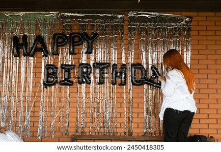 Girls decorating wall with happy birthday writing. preparation for birthdays party. 