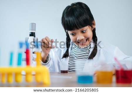 Similar – Serious kid playing with chemical liquids