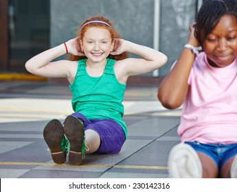 Girls doing sit-ups in physical education in elementary school