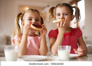 Girls eat breakfast on the table in the living room. Looking at camera. - Powered by Shutterstock