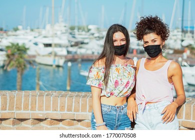 Girls with face mask posing for camera in a beach baceground