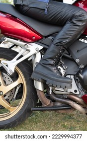 girls feet on the steps of a Honda motorcycle in a beautiful black boot