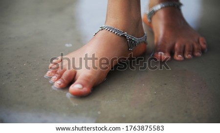 Girl's Feet In Water With Silver Angle Ornaments 
