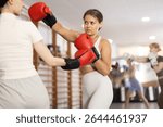 Girls are fighting at moment of contact in boxing match. Active training, practicing skills of defeating opponent in ring, boxing school for amateurs and professionals................