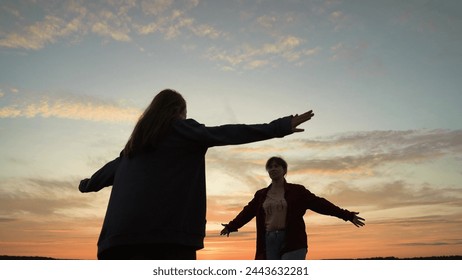 Girls friends hugging at sunset in park, silhouettes. Happy smiling girls women acquaintance friends girlfriends hugging embracing cuddling at sunset dawn sky clouds. Nice meeting, close relationship - Powered by Shutterstock