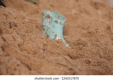 Girls Gum boot stuck in sand on a wet beach - Powered by Shutterstock