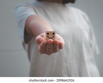 girl's hand holding a wooden block happy icon Demonstrating self-sufficiency in service at the highest level. - Shutterstock ID 2098661926