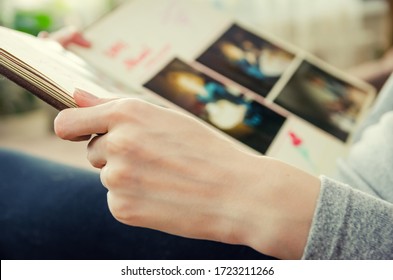 Girl's Hand Holds An Old Photo Album Close Up