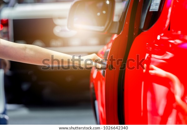 Girl\'s hand pulling a\
car\'s door handle