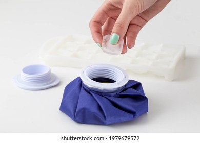 The Girl's Hand Puts A Piece Of Ice Into A Special Medical Bag On A White Background To Relieve Swelling And Inflammation In Case Of Injury And Bruise