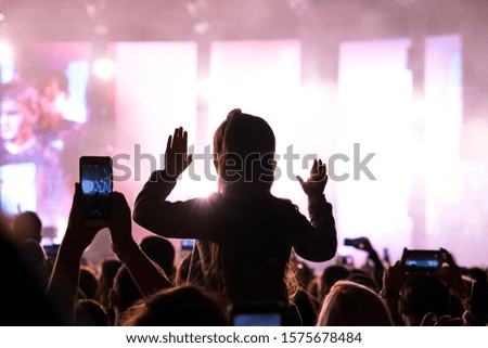 Girls with hands up dancing, singing and listening the music during concert show on summer music festival