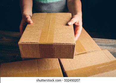 Girl's hands holding the package on the table