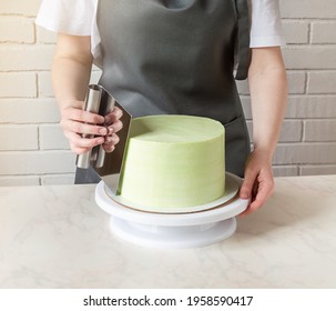 Girl's Hands Line With A Cream Spatula On A Round Cake. Decorating The Holiday Cake.