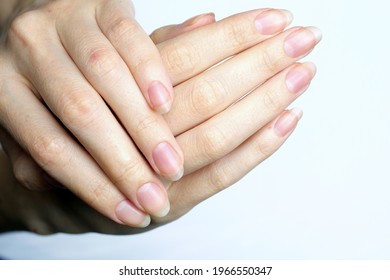 Girl's hands with long nails without nail polish. Natural female hands on a white background top view. Fingers with long nails, well-groomed hands. 