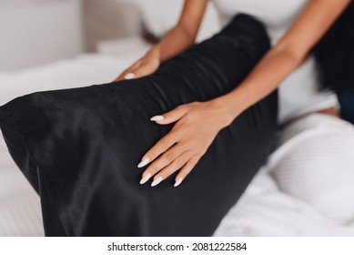 The girl's hands are stroking the pillow with a silk pillowcase. Focus on the pillowcase - Shutterstock ID 2081222584