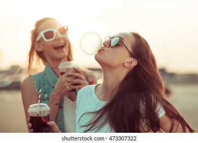 Girls have fun with drinks at the sunset - Shutterstock ID 473307322