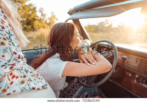 Girls have fun on\
the car in the\
countryside