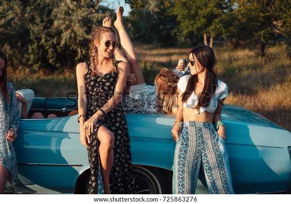 Girls have fun on\
the car in the\
countryside