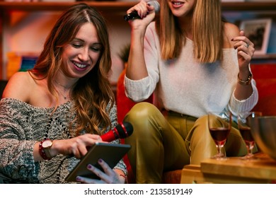 Girls Having Fun At Karaoke Night At Home.