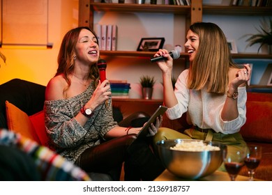 Girls Having Fun At Karaoke Night At Home.