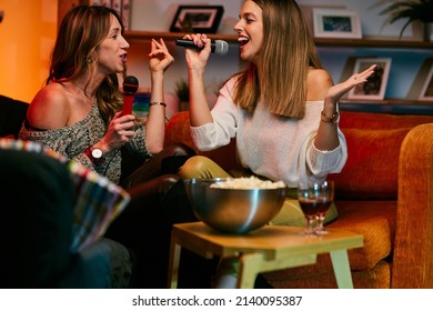 Girls Having Fun At Karaoke Night At Home.