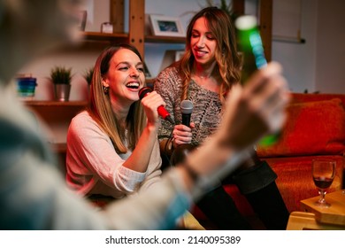 Girls Having Fun At Karaoke Night At Home.