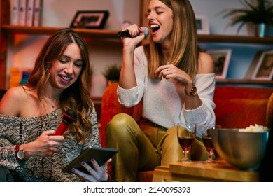 Girls Having Fun At Karaoke Night At Home.