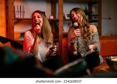 Girls Having Fun At Karaoke Night At Home.