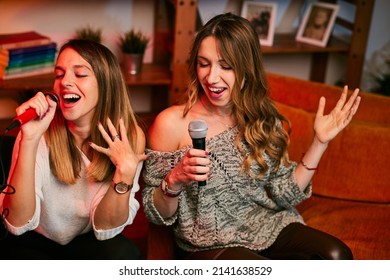 Girls Having Fun At Karaoke Night At Home.