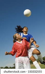 Girls Heading Soccer Ball During Match Against Blue Sky