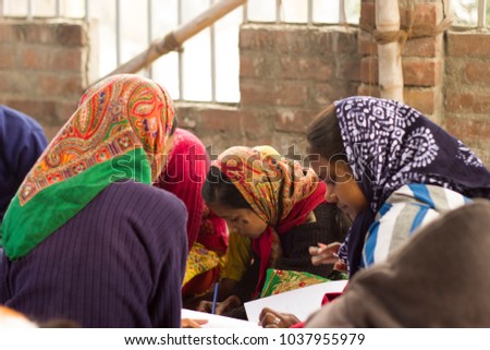 Girls in Indian village school study in a cirlcle, wearing head scarves