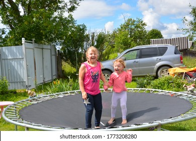 Girls Jump On A Trampoline Outside In Beautiful Sunny Weather. 