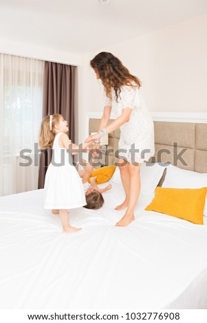 Similar – Relaxed mother and sons playing over the bed