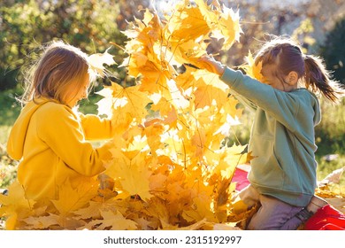 Girls kids playing jumping on trampoline with autumn leaves. Bright yellow orange maple foliage. Children walking, having fun in fall backyard. Outdoor funny happy season family activity, autumn park. - Powered by Shutterstock