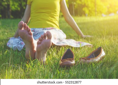 girls legs lying in grass barefoot without shoes