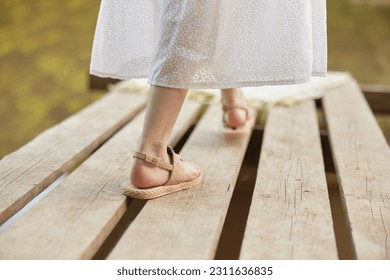 girl's legs in summer sandals on the pier in summer - Powered by Shutterstock