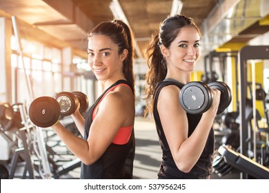 Girls Lifting Weights In Gym.