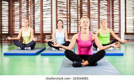 Girls meditating after fitness training in gym - Powered by Shutterstock